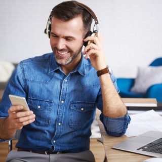 Happy man listening to music and using mobile phone