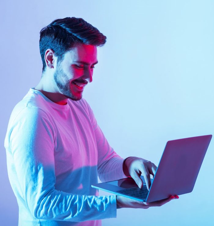 Work and play online. Happy guy holding laptop and typing