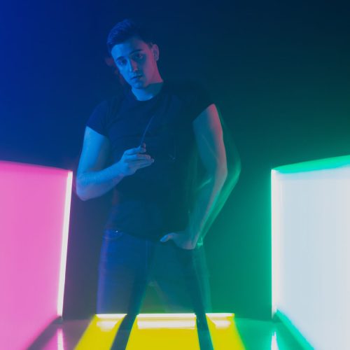 Group of male and female dancers in colorful neon light having fun dancing.