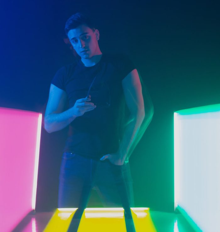 Group of male and female dancers in colorful neon light having fun dancing.