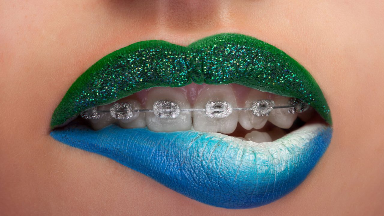 Close up mouth blue and green lips with glitter brackets