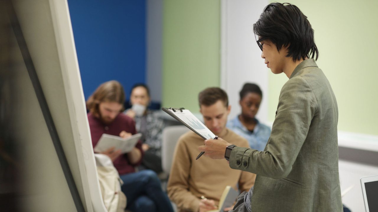 Asian teacher reading a lecture