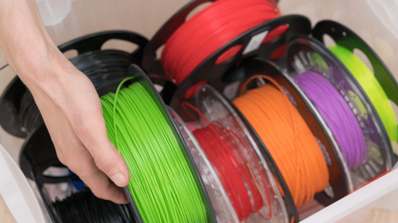 Main qui tient une bobine de filament PLA pour impression 3D