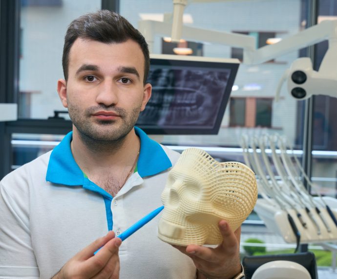 Man demonstrates a model of a human skull