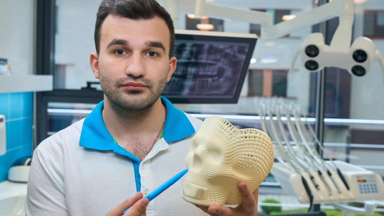 Man demonstrates a model of a human skull